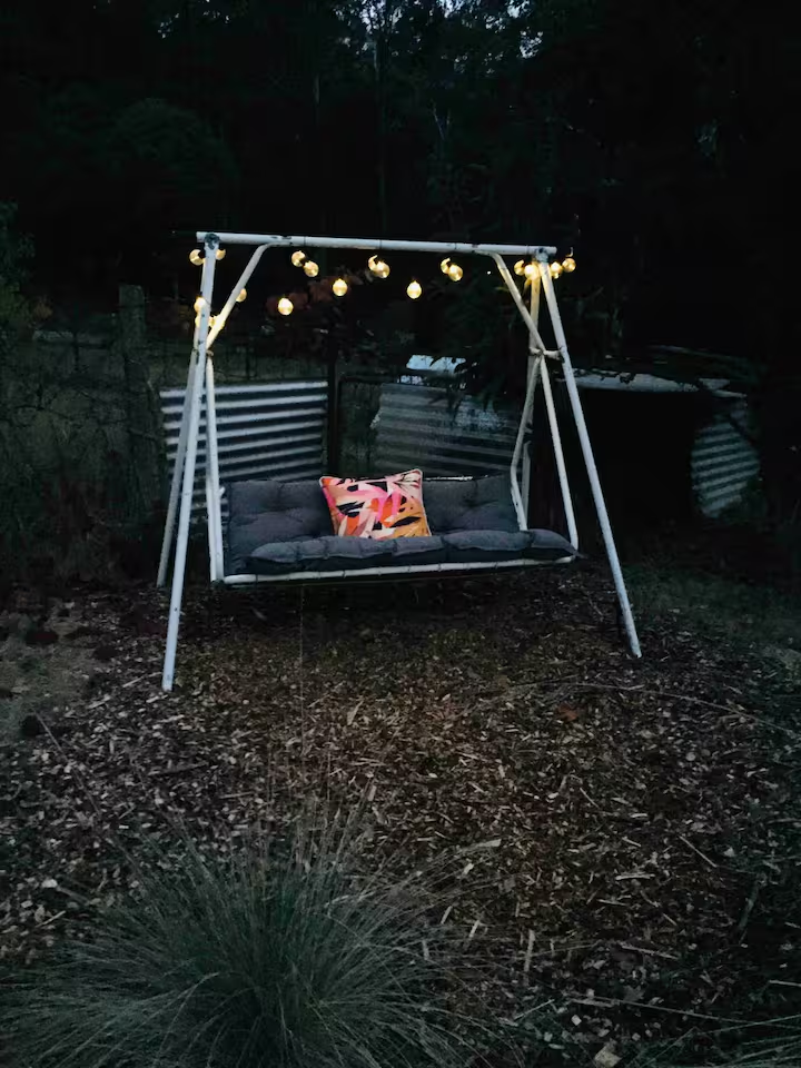 Bush swing under string lights at dusk in the backyard