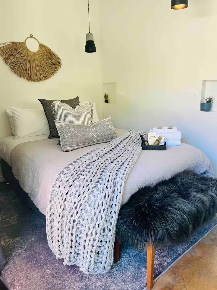 Linen-dressed queen bed with sheepskin throw